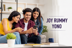 Three Indian Gen Z adults—two women and one man—looking at a smartphone together in a modern living room, representing the Joy Rummy Yono mobile app experience. The clean editorial-style featured image uses natural lighting, minimal design, and the title 'Joy Rummy Yono' without gambling-related visuals.